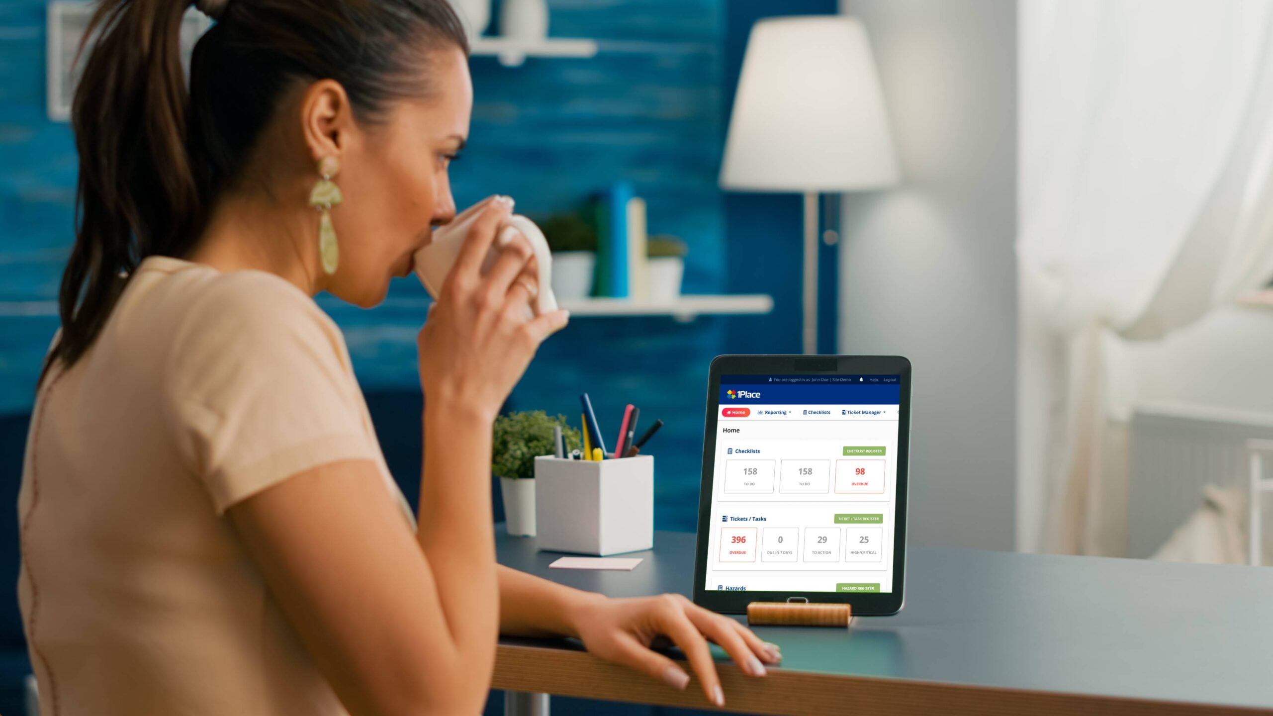 freelancer-woman-holding-cup-coffee-looking-tablet-computer-with-mock-up-green-screen-chroma-key-sitting-desk-table-caucasian-female-browsing-isolated-device-from-home-office-room-1-scaled